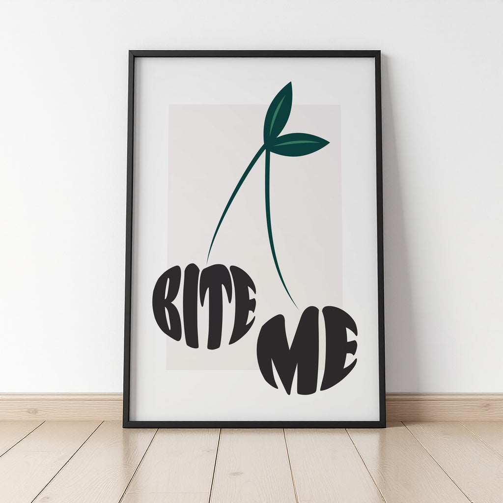 Framed artwork with a cherry design and 'BITE ME' text on a white wall.