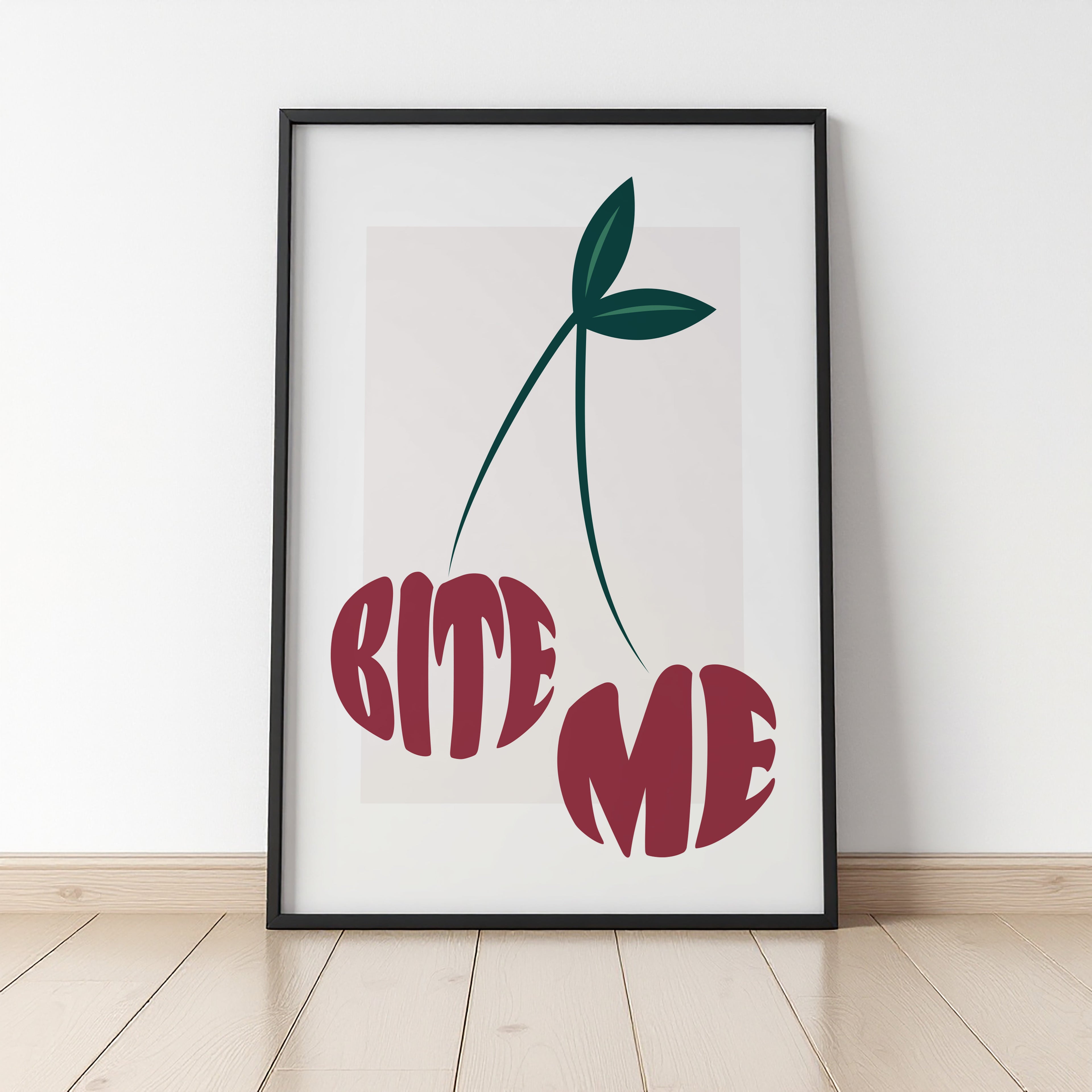 Framed artwork with cherry graphic and 'BITE ME' text on a white wall.