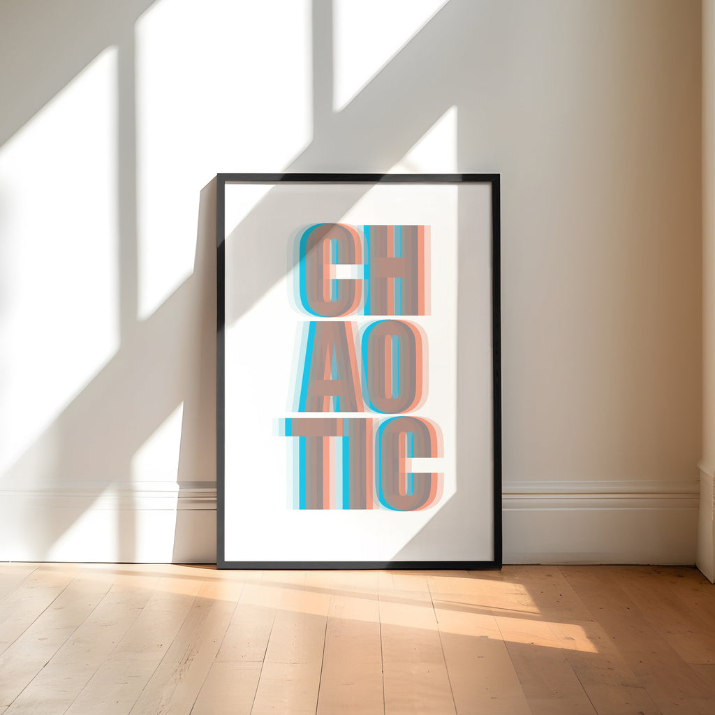 Framed artwork with 'CHAOTIC' text in a bright room with large windows.