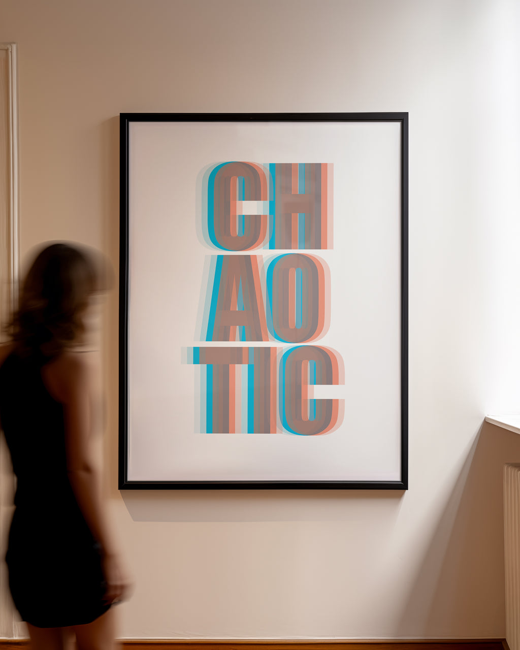 Framed artwork with 'CHAOTIC' text in a 3D effect on a wall, person standing to the side.