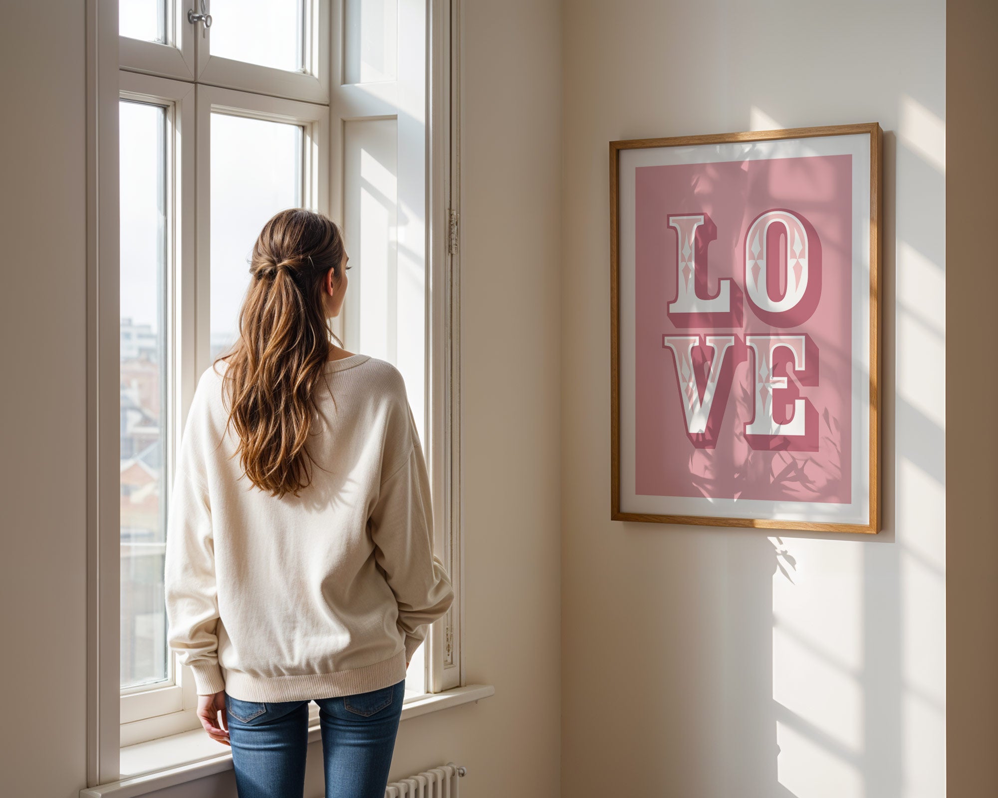 Woman standing by a window looking outside, with a 'LOVE' framed picture on the wall.