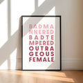 Framed poster with text saying 'Bad Mannered, Bad Tempered, Outrageous Female' on a white background.