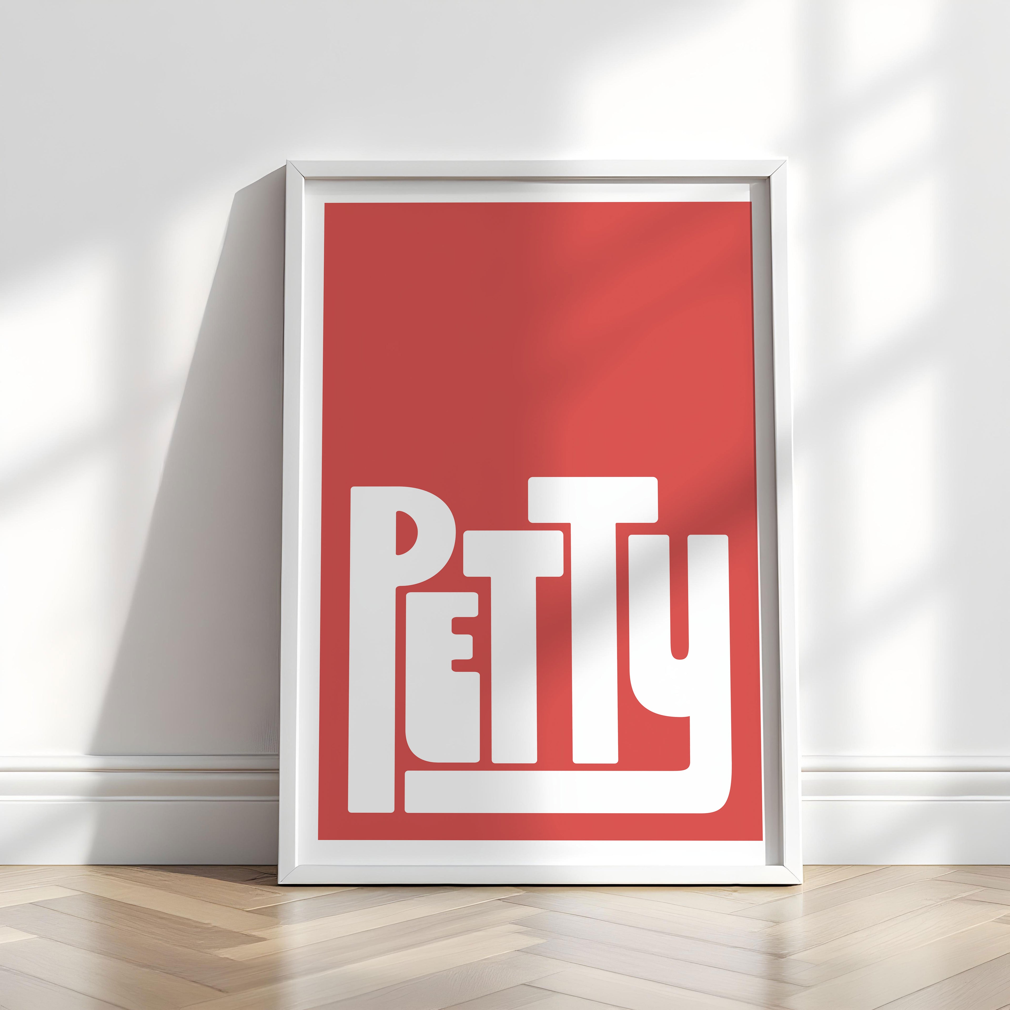 Framed poster with 'PETTY' design on a red background in a minimalistic room.
