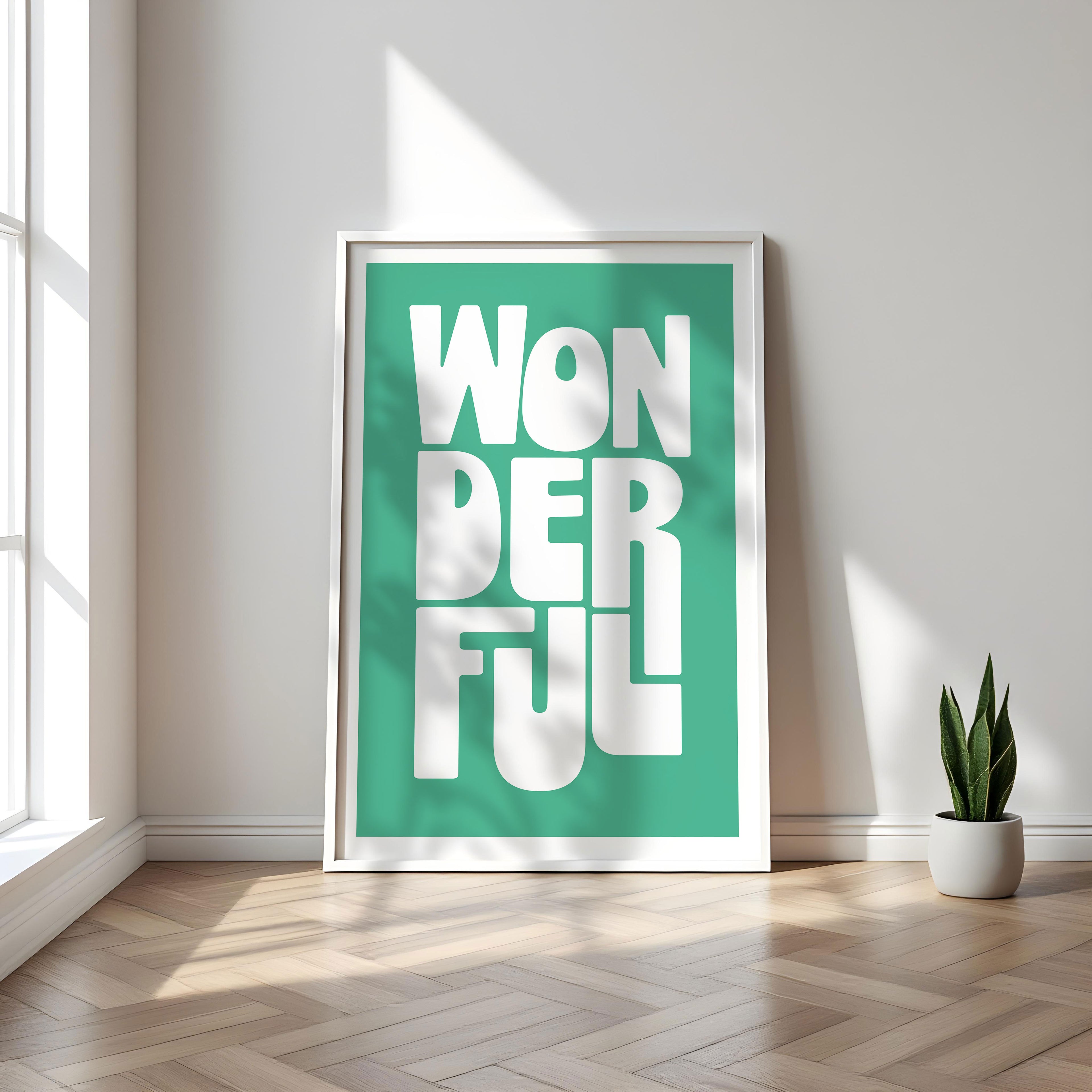 Framed poster with 'WONDERFUL' text on a teal background in a bright room with a plant.